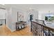 Hallway with hardwood floors, views of the bedroom, staircase railings, and a decorative pendant light fixture at 18745 Bluff Point Rd, Cornelius, NC 28031