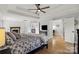 Spacious main bedroom with hardwood floors, a tray ceiling, and a fireplace in the background at 18745 Bluff Point Rd, Cornelius, NC 28031