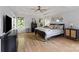 Serene main bedroom with hardwood floors, a ceiling fan, and plenty of natural light from the windows at 18745 Bluff Point Rd, Cornelius, NC 28031