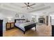 Bright main bedroom featuring a fireplace, hardwood floors, ceiling fan, and stylish decor at 18745 Bluff Point Rd, Cornelius, NC 28031