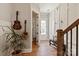Bright entryway with hardwood floors, white trim, decorative guitars, and staircase at 20216 Shaffer Bach Ln, Charlotte, NC 28277