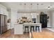 Open kitchen with white cabinets, island seating, stainless appliances, and stylish accents at 20216 Shaffer Bach Ln, Charlotte, NC 28277