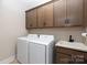 Laundry room with modern washer and dryer, sink, and upper cabinets at 20216 Shaffer Bach Ln, Charlotte, NC 28277