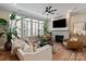 Bright living room has a brick fireplace, large windows, and stylish decor at 20216 Shaffer Bach Ln, Charlotte, NC 28277