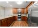 Modern kitchen featuring wood cabinetry, stainless steel appliances, and a central island with granite countertops at 207 Crystal Springs Ln, Shelby, NC 28150