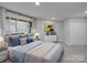 Bright bedroom featuring a large window with wooded views, a comfortable bed, and ample closet space at 2143 Manawa Ln, Tega Cay, SC 29708