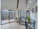 Bright living room with a spiral staircase, large windows, and a sliding glass door to a deck with wooded views at 2143 Manawa Ln, Tega Cay, SC 29708