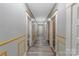 Long hallway with doors, white trim, gray flooring, and modern lighting at 224 E Steele St, Salisbury, NC 28144