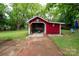 Red outbuilding featuring brick pathway, surrounded by mature trees at 224 E Steele St, Salisbury, NC 28144