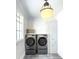 Bright laundry room with modern front-load washer and dryer set, ample storage cabinets, and white trim at 2270 New Gray Rock Rd, Fort Mill, SC 29708