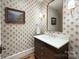 Stylish powder room with decorative wallpaper, marble countertop vanity, and gold fixtures at 2270 New Gray Rock Rd, Fort Mill, SC 29708