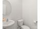 Modern powder room featuring a pedestal sink, round mirror, and neutral color palette at 2340 Lanza Dr, Charlotte, NC 28215