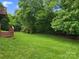 Expansive backyard with well-maintained green grass and some trees in the background at 2821 Providence Spring Ln, Charlotte, NC 28270