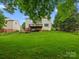 Rear view of a house with a grassy backyard, deck, and stairs at 2821 Providence Spring Ln, Charlotte, NC 28270