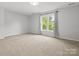 Bedroom with neutral carpet and large window overlooking trees at 2821 Providence Spring Ln, Charlotte, NC 28270