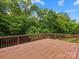 Wooden deck with railing overlooking a lush green forest and blue sky at 2821 Providence Spring Ln, Charlotte, NC 28270