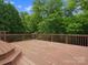 Spacious wooden deck with railing overlooking a lush green forest at 2821 Providence Spring Ln, Charlotte, NC 28270
