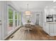 Bright dining area with large windows, hardwood floors, and a stylish light fixture above the table at 2821 Providence Spring Ln, Charlotte, NC 28270