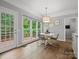 Bright dining area with doors to deck, large windows, hardwood floors and a stylish light fixture at 2821 Providence Spring Ln, Charlotte, NC 28270