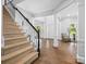 Bright foyer with hardwood floors, white columns, and staircase with a black handrail at 2821 Providence Spring Ln, Charlotte, NC 28270