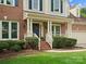 Inviting brick home showcasing a covered front porch with manicured landscaping at 2821 Providence Spring Ln, Charlotte, NC 28270