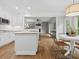 Spacious kitchen with an island, white cabinetry, granite countertops, and open floor plan to the living room at 2821 Providence Spring Ln, Charlotte, NC 28270
