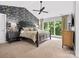 Well-lit main bedroom featuring a large window, dark furniture, and floral wallpaper at 2821 Providence Spring Ln, Charlotte, NC 28270