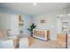 Bright Bedroom featuring a wooden crib, white armchair, and whimsical decor for a playful touch at 3471 Melwood Estates Dr, Denver, NC 28037