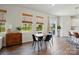 Bright dining area featuring a table with black chairs, wood blinds, and an adjacent living space at 3471 Melwood Estates Dr, Denver, NC 28037