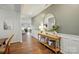 Inviting hallway with wood floors, decoratively appointed with a console table and round mirror reflecting interior space at 3471 Melwood Estates Dr, Denver, NC 28037