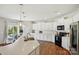 Open kitchen with white cabinets, stainless steel appliances, island with seating, and access to outdoor patio at 3471 Melwood Estates Dr, Denver, NC 28037