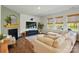 Cozy living room featuring a fireplace, plush seating, and large windows with views of the backyard at 3471 Melwood Estates Dr, Denver, NC 28037
