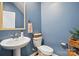 Stylish powder room with blue walls, pedestal sink, and decorative mirror providing a welcoming space at 3471 Melwood Estates Dr, Denver, NC 28037