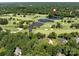 Stunning aerial view of golf course with ponds, near houses nestled among a lush green tree canopy at 3531 Bon Rea Dr, Charlotte, NC 28226