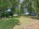 Landscaped backyard featuring a pond, outbuilding, and tree lined property at 3531 Bon Rea Dr, Charlotte, NC 28226