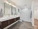 Modern bathroom featuring a double vanity and a glass enclosed shower with white tile at 3531 Bon Rea Dr, Charlotte, NC 28226