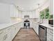 Newly remodeled kitchen featuring sleek white cabinets, modern appliances, and laminate wood floors at 3531 Bon Rea Dr, Charlotte, NC 28226