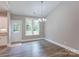 Bright dining area with hardwood floors, a modern chandelier, and access to the backyard at 501 Old Speedway Nw Dr # 1, Concord, NC 28027