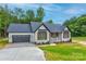 Charming single-story home with a gray roof, brick accents, and an attached two-car garage at 501 Old Speedway Nw Dr # 1, Concord, NC 28027