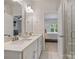 Elegant bathroom with double vanity sinks, modern fixtures, and a glass-enclosed shower, open to the bedroom at 513 Cubitt Ct, Charlotte, NC 28205