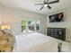 Bright bedroom with a large window, ceiling fan, and dark wood dresser with a wall-mounted television at 513 Cubitt Ct, Charlotte, NC 28205