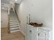 Inviting entryway featuring hardwood floors, staircase, and a decorative cabinet with rustic accents at 513 Cubitt Ct, Charlotte, NC 28205