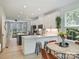 Bright kitchen featuring white cabinets, stainless steel appliances, and a central island with bar stool seating at 513 Cubitt Ct, Charlotte, NC 28205