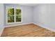An open bedroom featuring luxury vinyl flooring, blue walls, and views of the outdoors at 5414 Leaford Ct, Charlotte, NC 28227