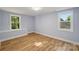 Bedroom with light blue walls, wood floors, and two windows at 5414 Leaford Ct, Charlotte, NC 28227