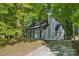 Home exterior with a gray facade, black accents, and a chimney amidst lush trees at 5414 Leaford Ct, Charlotte, NC 28227