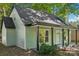 Charming home featuring a covered porch with dark columns and light green siding, nestled among mature trees at 5414 Leaford Ct, Charlotte, NC 28227