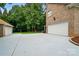 Long driveway with two garages surrounded by mature landscaping, offering ample parking space at 6324 Old Fox Hunt Ln, Mint Hill, NC 28227