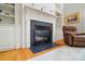 Close up of a living room fireplace with built-in shelving and hardwood flooring at 6324 Old Fox Hunt Ln, Mint Hill, NC 28227
