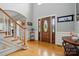 Spacious foyer features hardwood floors, staircase and wooden front door with glass inserts at 6324 Old Fox Hunt Ln, Mint Hill, NC 28227